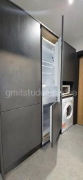 Storage press with mop and hoover as well as an integrated fridge freezer, microwave and tumble drier. 