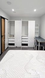 Main bedroom with two double wardrobes and drawer storage, desk, chair, bedside locker and shelf unit on the desk.